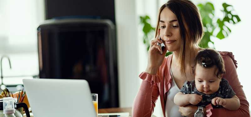 Young mother holding child and talking on phone