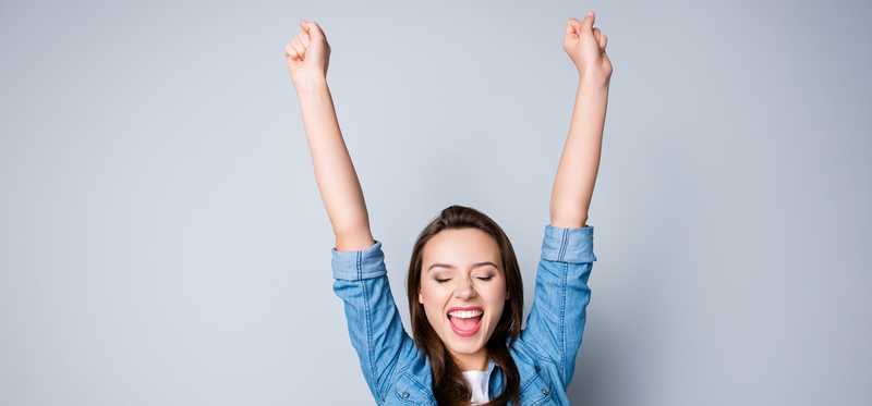 Happy person with arms up in the air.