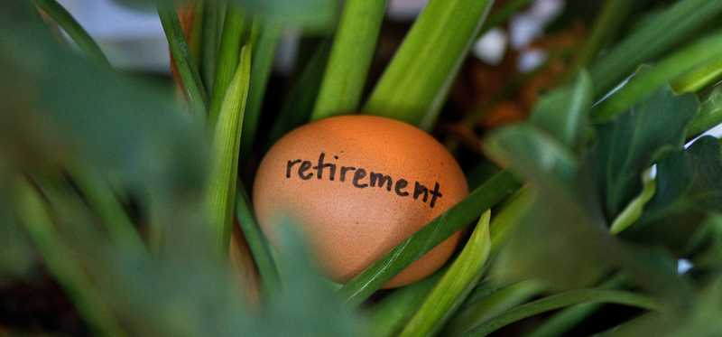 An egg with the word Retirement written on it sitting in a nest.