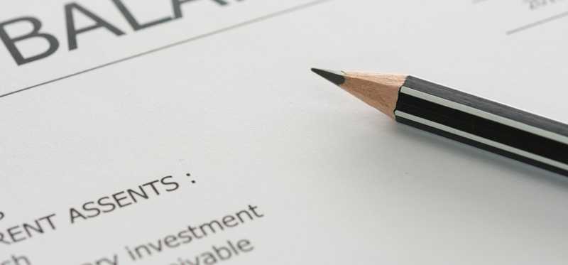 Pencil resting on a balance sheet.