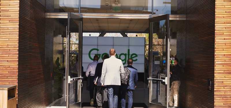 Executives walking into Google's headquarters entrance.