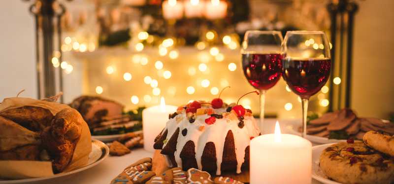 Various desserts and two glasses of wine are shown