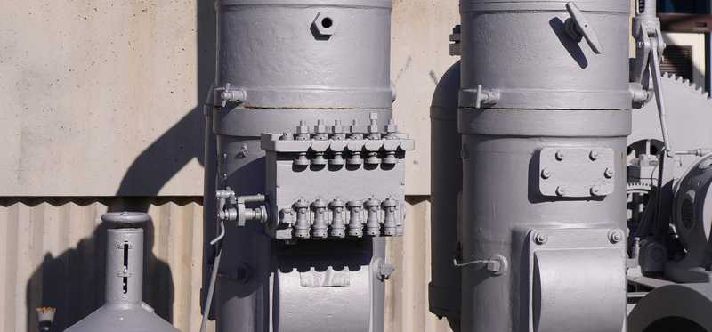 Some industrial electric motors alongside a wall.