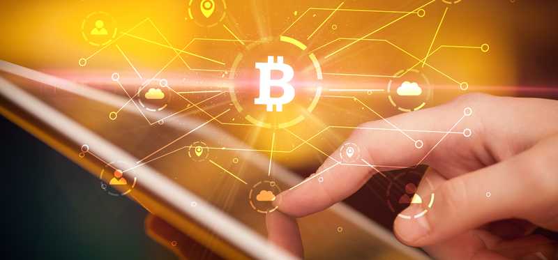 Close-up of finger tapping tablet with Bitcoin imagery representing global connectivity.