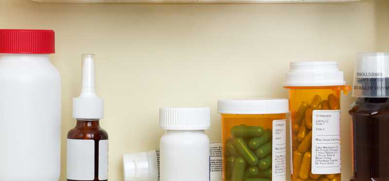 bottles of prescription medicine sitting on shelves in cabinet