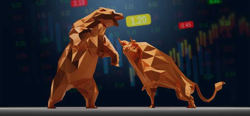 Origami of bear fighting with bull against backdrop of charted numbers.