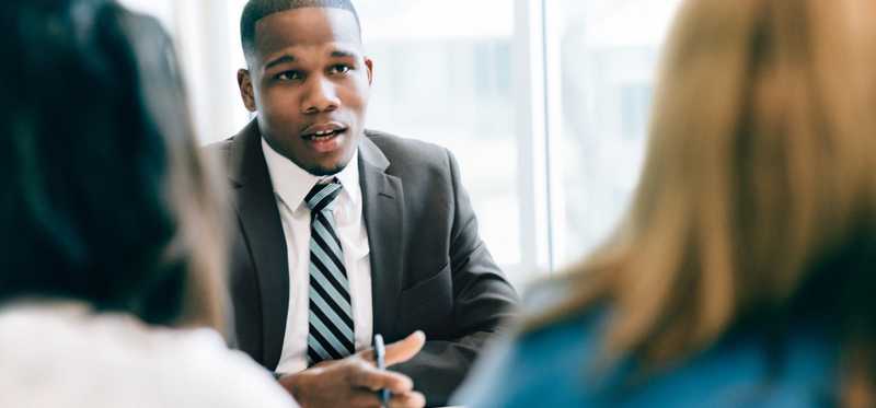 Businessperson giving advice to two clients.