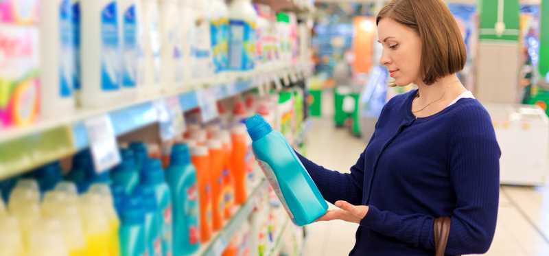Person picking out detergent in a grocery store.