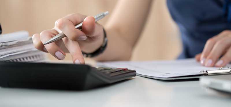 Person typing numbers into a calculator.