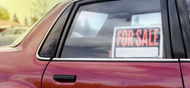 Red car with for sale sign in window