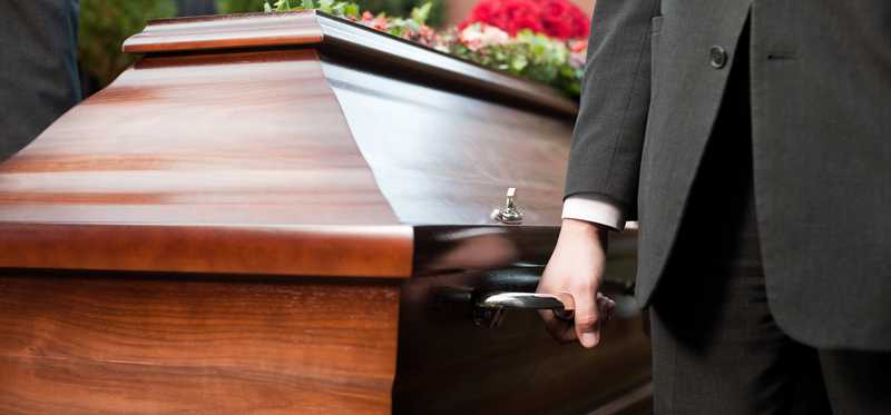 Wooden casket being carried.