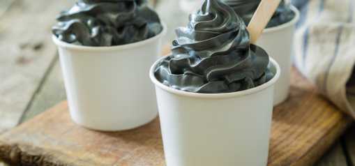 Three cups of ice cream colored gray with charcoal sitting on a table