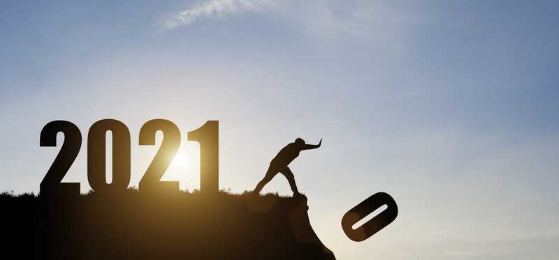 Man pushing zero off cliff that has large 2021 sign