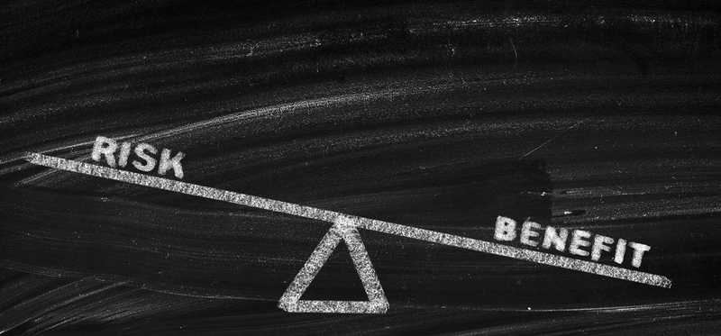 Balancing risk and benefit as drawn on chalkboard.
