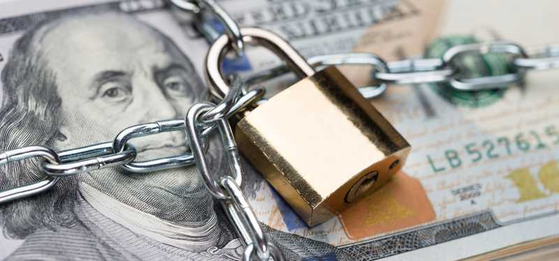 Chain and padlock on a bundle of cash.