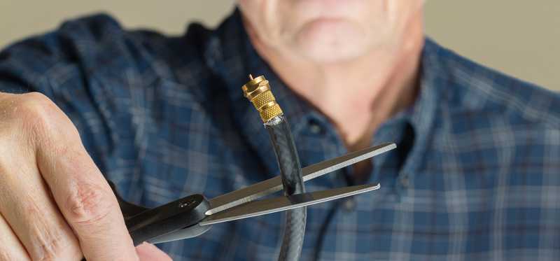 man cutting cable cord with scissors