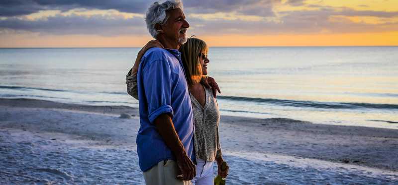 An older couple on the beach at sunset