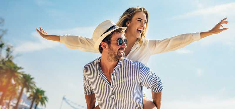 Two people playing outdoors wearing stylish summer clothing.