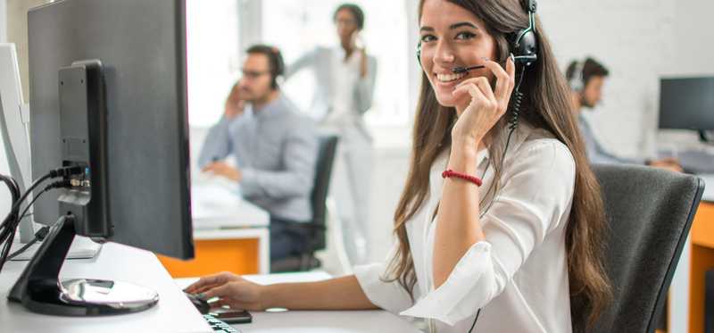 A woman wears a headset as she sits in a call center
