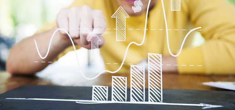 Person studying data on a bar graph.