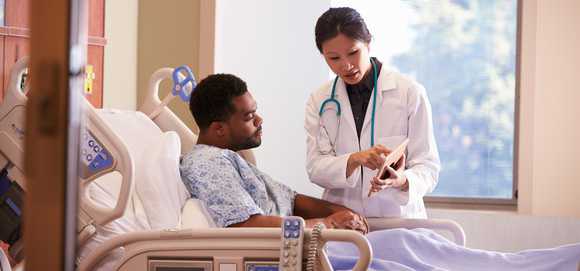 Doctor discusses info on a tablet with patient.