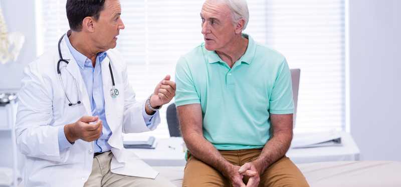 A doctor talking to older male patient.