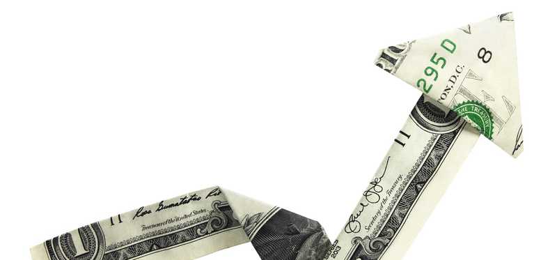 A dollar bill folded into an upward-pointing arrow