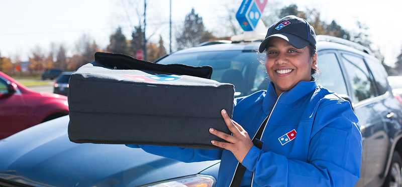 A Domino's driver delivering pizza.