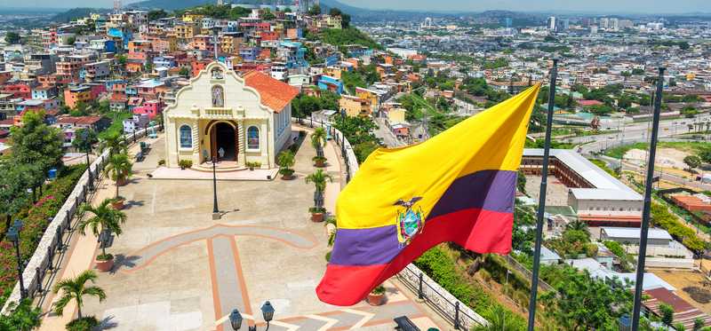 Ecuador's flag waves over a skyline.
