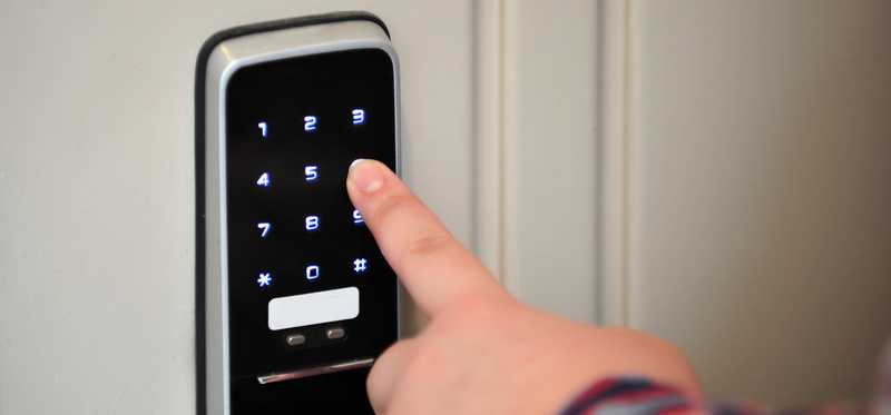 Hand pushing buttons on an electronic lock.