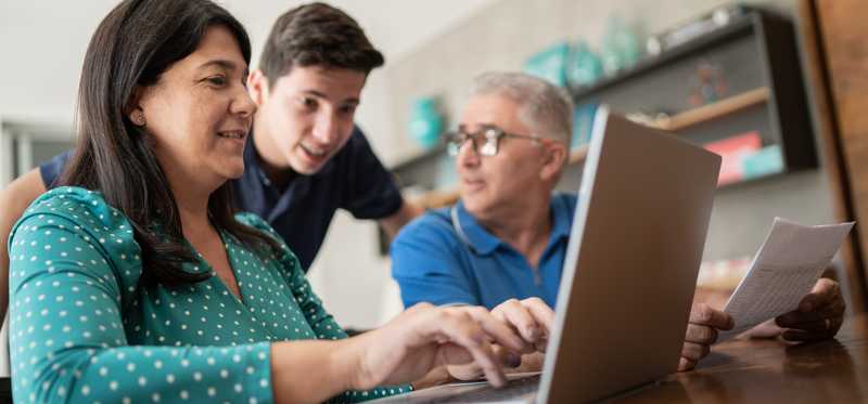 People share information on a laptop at home.