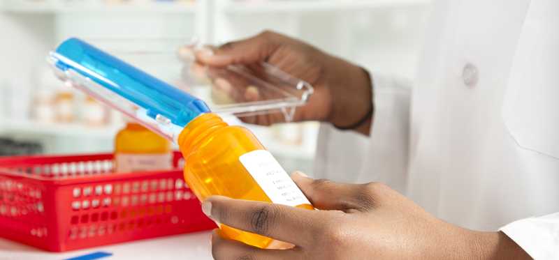 Two hands filling a generic pill bottle.