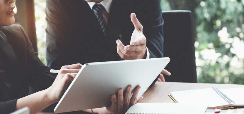 Financial advisor and client look at notebook
