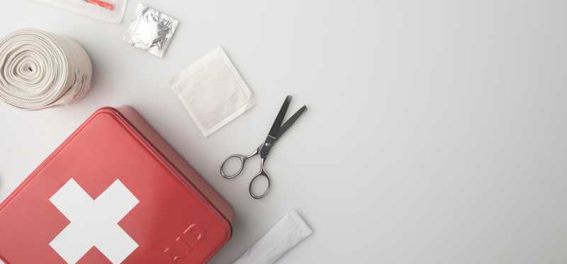 A first aid kit with the contents laid out.