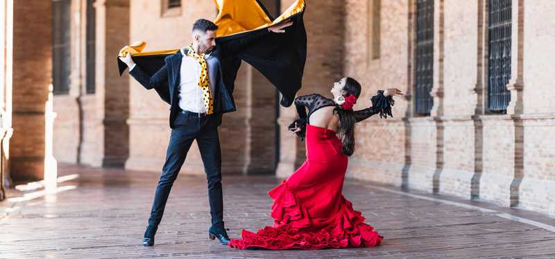 Two people dancing flamenco in a plaza.
