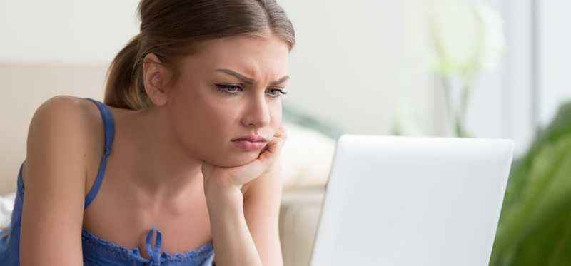 Frustrated and upset person looking at laptop.