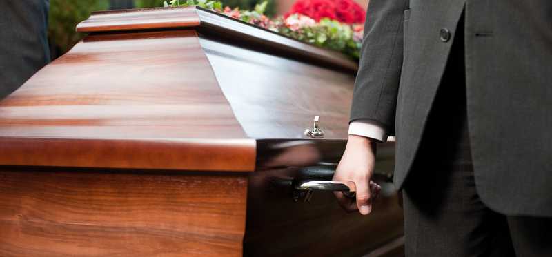 Casket being carried by men in suits
