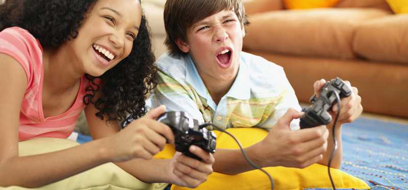 Two kids play a video game together.