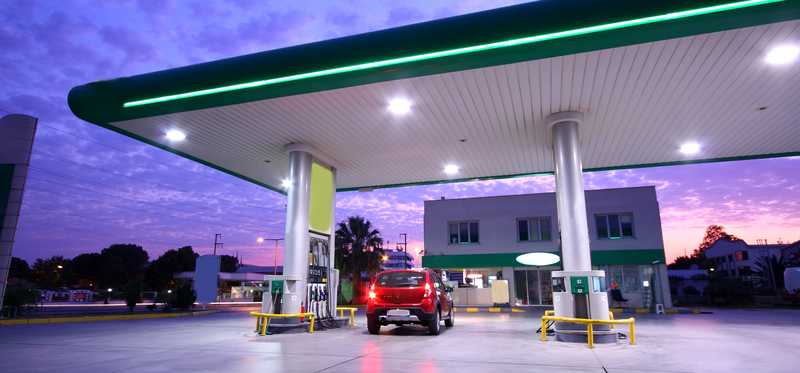 An exterior shot of gas pumps and a convenience store.