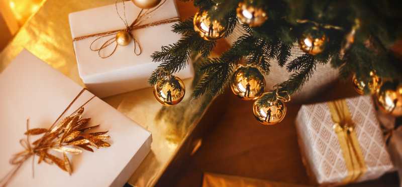 Gifts under tree with gold ball decorations