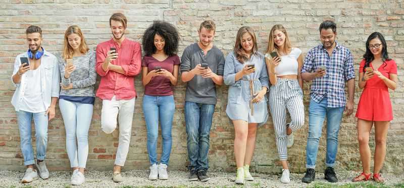group of young people looking at smartphones