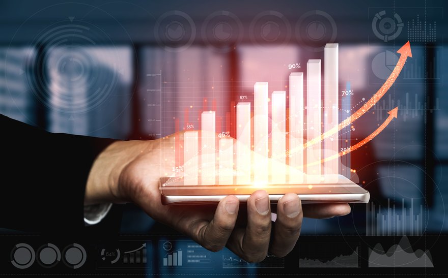 Hand holding financial markets indicator showing assets trending upward.