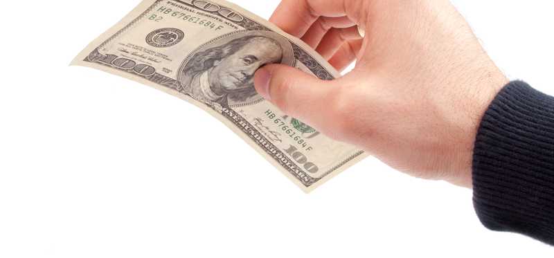 Hand holding 100 dollar bill.