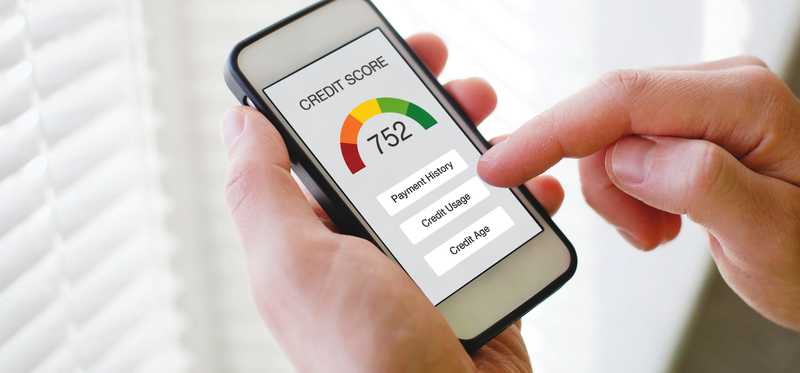 Hands holding a phone showing a credit score.