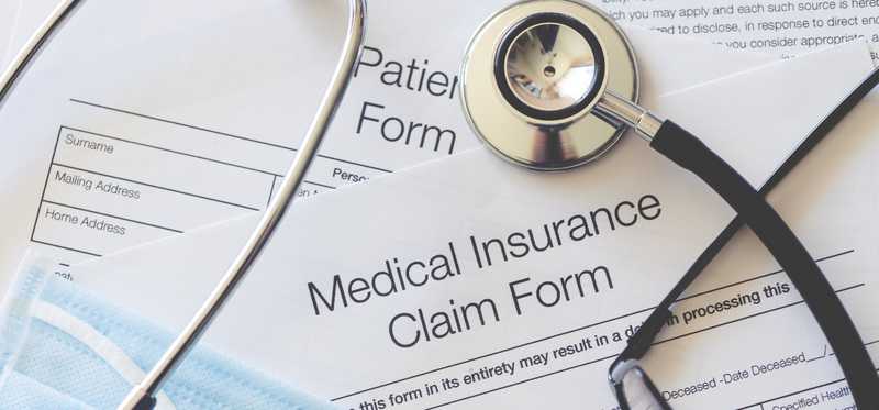 Health insurance forms and a stethoscope and mask.