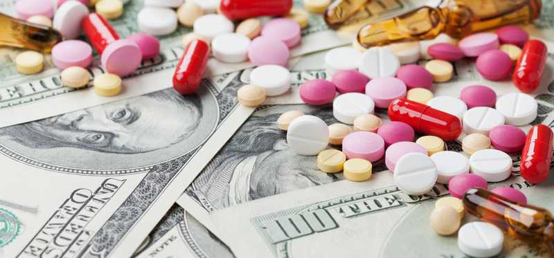 Pills scattered on top of money.