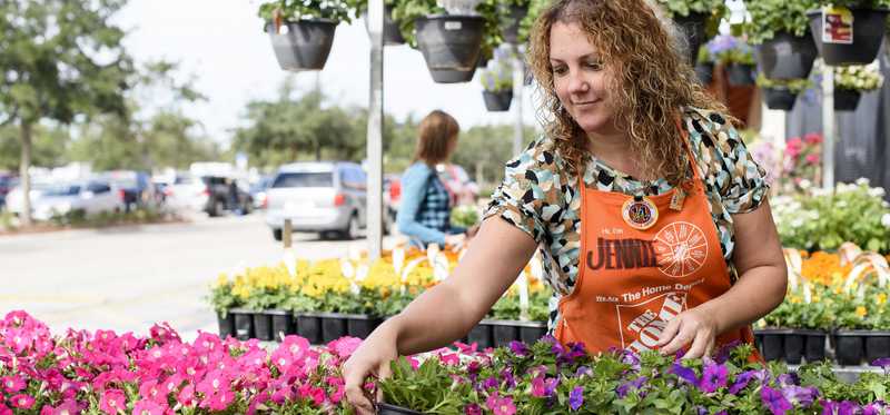 Home Depot employee arranges flowers.
