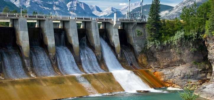 A hydroelectric dam with mountainous backdrop.
