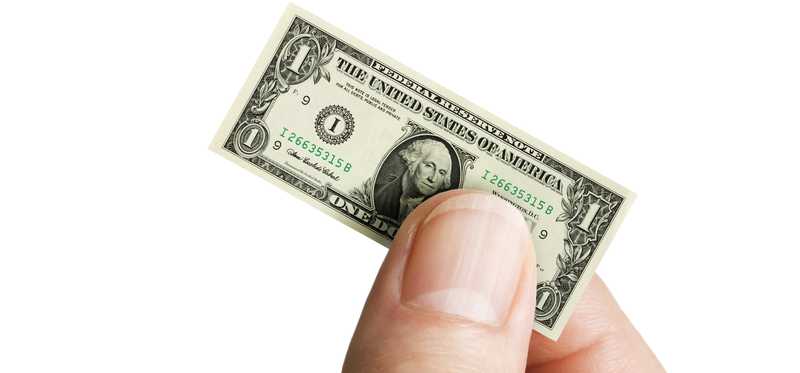 A hand holding a very small dollar bill.