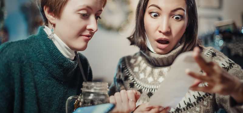 Two people looking shocked at a receipt.